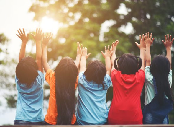 Group of kids friends arm around sitting together